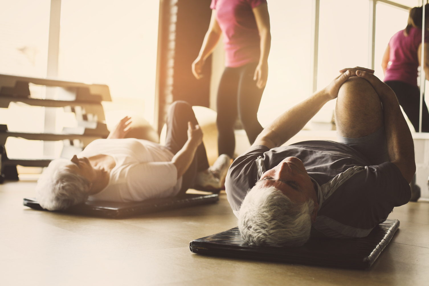 In Motion: Elderly man and woman stretching on mats